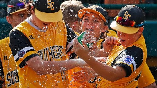 Peachtree City’s Jansen Kenty (lef), and James Hopper (right) get a shower from Will Clem after getting the final out of a 4-3 complete-game win over Grosse Pointe Woods, Mich., in an elimination baseball game Wednesday, Aug. 22, 2018, at the Little League World Series tournament in South Williamsport, Pa.