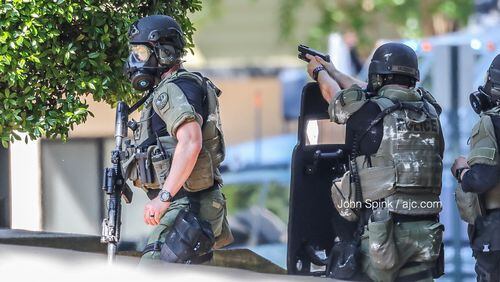Marietta SWAT officers gather outside The Park on Windy Hill apartment complex on Windy Hill Road where a wanted man is hiding inside an attic Thursday morning.