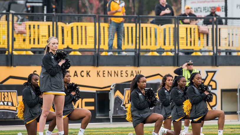 Some of the Kennesaw State cheerleaders resumed taking a knee during the national anthem at the Nov. 18 home game. On the previous Saturday, which was Veterans Day and the cheerleaders’ first time on the field for the anthem since the kneeling controversy began, none of the cheerleaders took a knee. Photo: Cory Hancock / Special to the AJC