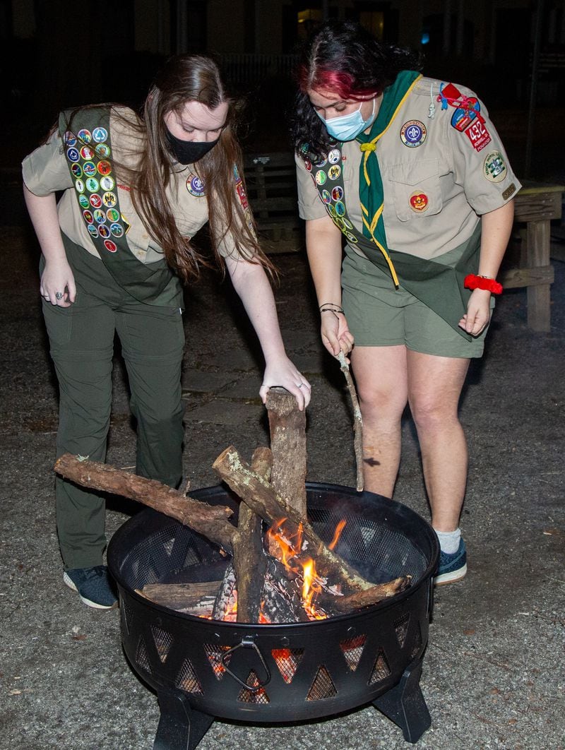Veronica Roark (left) & Zoe Rosenberg tend to a fire outside the Roswell United Methodist Church scout hut in Roswell. The two are part of the all-girls Scout Troop 432, that meets at the church on Thursday nights. They are the first girls in the Northern Ridge Scout District to earn the Eagle Scout rank, and are among the nation's Inaugural Class of Female Eagle Scouts. PHIL SKINNER FOR THE ATLANTA JOURNAL-CONSTITUTION.