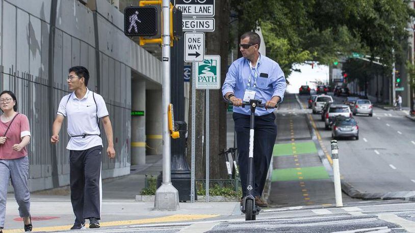 A man rides a shareable e-scooter along Centennial Olympic Park Drive last year. (Alyssa Pointer/alyssa.pointer@ajc.com)
