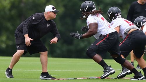 Down in the trenches: Offensive line coach Chris Morgan gets in some work with guard James Carpenter during Wednesday's minicamp practice in Flowery Branch. (Curtis Compton/ccompton@ajc.com).