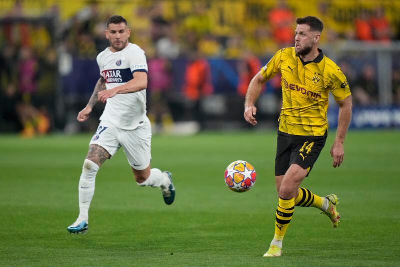 Dortmund's Niclas Fuellkrug, right, is challenged by PSG's Lucas Hernandez during the Champions League semifinal first leg soccer match between Borussia Dortmund and Paris Saint-Germain at the Signal-Iduna Park stadium in Dortmund, Germany, Wednesday, May 1, 2024. (AP Photo/Matthias Schrader)