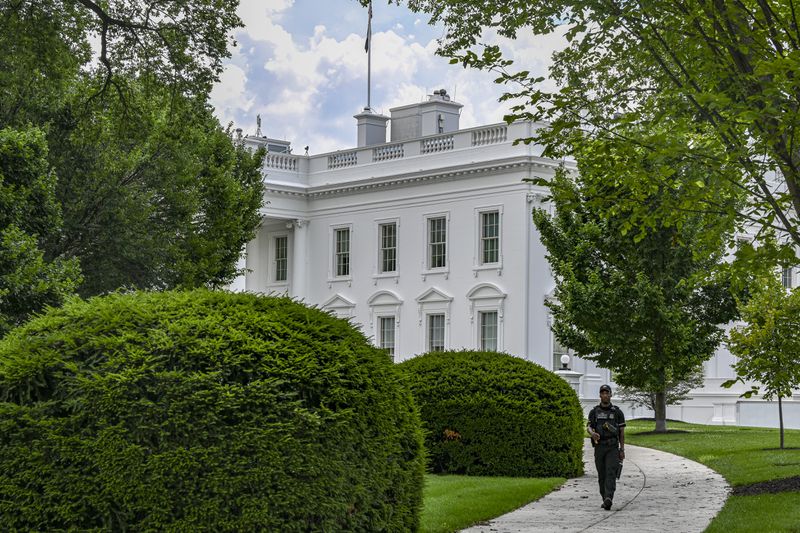 President Joe Biden will deliver remarks from the White House on his efforts to lower health care costs. A Secret Service agent is scene walking along the north front of the White House on July 5, 2023.  (Kenny Holston/The New York Times)