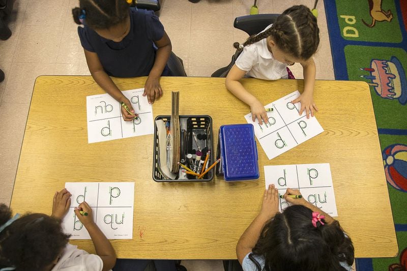 Kindergarten students trace letters and digraphs onto a plastic gridded sheet during their phonics lesson at Benteen Elementary School in Atlanta. The plastic grid is used as a sensory tool to help students remember their lesson. 