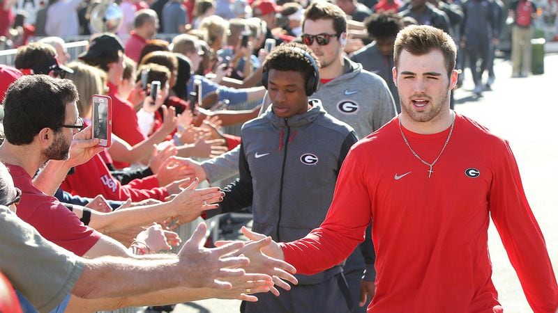 Georgia quarterback Jake Fromm gives fans high-fives while arriving for the team photo at Rose Bowl Stadium on Sunday, Dec. 31, 2017, in Pasadena, Calif.