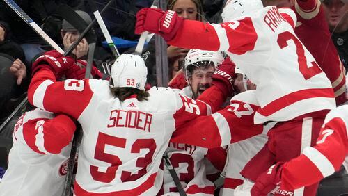 Detroit Red Wings center Dylan Larkin (71) celebrates with teammates after scoring against the Toronto Maple Leafs in overtime of an NHL hockey game Saturday, April 13, 2024, in Toronto. (Frank Gunn/The Canadian Press via AP)