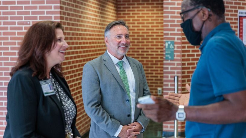Principal Laurie Woodruff (left) and Fulton County Schools Superintendent Mike Looney speak with a parent on the first day of school at Sandy Springs Charter Middle School in Sandy Springs on Monday, Aug. 8, 2022. The school board on Thursday approved midyear raises for employees. (Arvin Temkar / arvin.temkar@ajc.com)