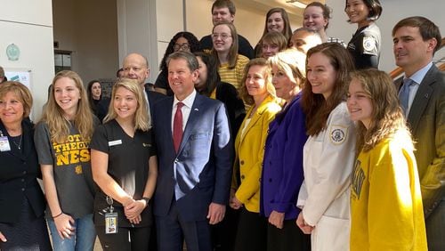 Georgia Gov. Brian Kemp (center in the front row) is joined by some Kennesaw State University students during a visit to the Kennesaw campus in February. Kemp has allocated $11.5 million to the University System of Georgia, which includes KSU, for student mental health programs. ERIC STIRGUS/ESTIRGUS@AJC.COM