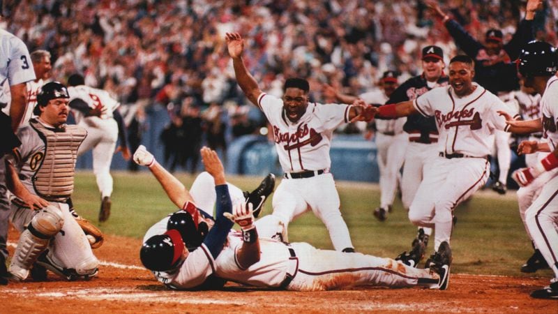 Sid Bream, prone on the ground, gets mobbed by teammates after scoring the winning run in the bottom of the 9th inning of Game 7 of the 1992 NLCS against the Pittsburgh Pirates.
