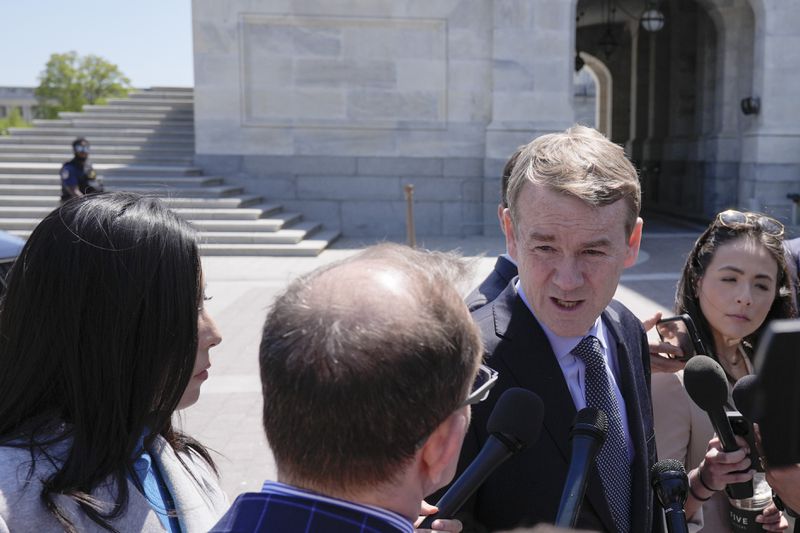 Sen. Michael Bennet, D-Colo., center, speaks to reporters outside the U.S. Capitol, Tuesday, April 23, 2024, in Washington as Senators prepare to consider legislation that would force TikTok's China-based parent company to sell the social media platform under the threat of a ban, a contentious move by U.S. lawmakers. (AP Photo/Mariam Zuhaib)