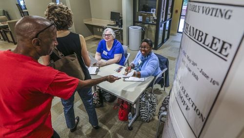 Chamblee: (left to right) Gary Peeler and Roberta Goldbaugh prepare to vote early in the Georgia 6th District runoff as poll workers Nancy Love and Esther Wilder check their papers at the North DeKalb Senior Community Center in Chamblee on Tuesday May 30, 2017. Early in-person voting got underway Tuesday in Georgia’s 6th Congressional District, kicking off the official countdown to the June 20 runoff between Republican Karen Handel and Democrat Jon Ossoff. JOHN SPINK/JSPINK@AJC.COM.