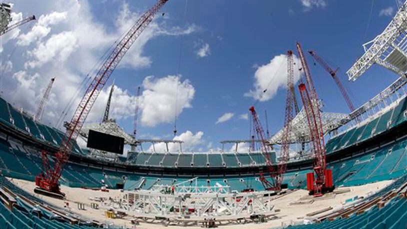 Workers assemble trusses in the center of the field that will support a 530,000-square-foot canopy at the Miami Dolphins' NFL football stadium, Thursday, June 2, 2016, in Miami Gardens, Fla. The first game of 2016 is three months away, and the stadium is far from ready. But Dolphins officials say they're on schedule with a major renovation, thanks to crews working around the clock since late December, which has pushed the cost to $500 million. (AP Photo/Alan Diaz)