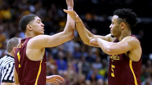 Loyola guard Lucas Williamson (left) gets five from Marques Townes after sinking a basket and drawing a foul against Kansas State during the first half in a regional final NCAA college basketball game on Saturday.