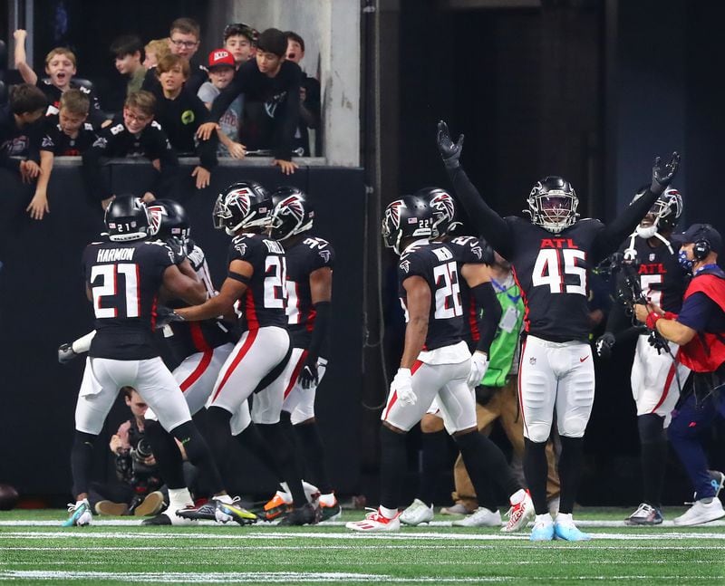 Falcons linebacker Deion Jones (right) and teammates react after defensive lineman Marlon Davidson intercepts Buccaneers quarterback Tom Brady for a pick-six at the end of the second quarter in a NFL football game on Sunday, Dec 5, 2021, in Atlanta.   “Curtis Compton / Curtis.Compton@ajc.com”`
