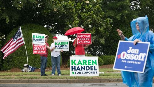 Supporters of Democrat Jon Ossoff and Republican Karen Handel brave the rain Tuesday. (Credit: Jessica McGowan / Getty Images)