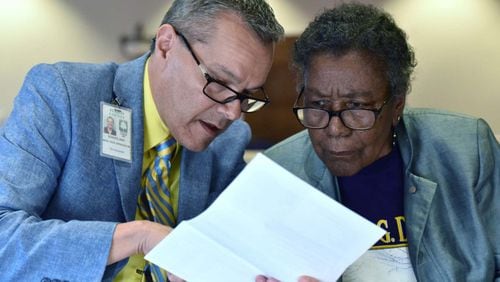 Emil Schultz (left), appraiser, helps Fulton County resident Marie F. Blake with her annual notice of assessment during an emergency town hall meeting earlier this month. Hyosub Shin/AJC