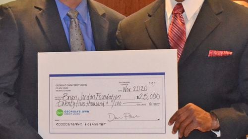 Dave Preter (left), president and CEO of Georgia's Own Credit Union, and Brian Jordan are pictured as Preter presents a donation for the Brian Jordan Foundation. Courtesy of Brian Jordan Foundation