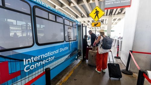 Passengers board the terminal-to-terminal shuttle at the international terminal Tuesday, Sept. 29, 2023.  (Steve Schaefer/steve.schaefer@ajc.com)