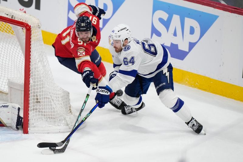 Tampa Bay Lightning center Tyler Motte (64) attempts a shot against Florida Panthers defenseman Oliver Ekman-Larsson (91) during the first period of Game 1 of the first-round of an NHL Stanley Cup Playoff series, Sunday, April 21, 2024, in Sunrise, Fla. (AP Photo/Wilfredo Lee)