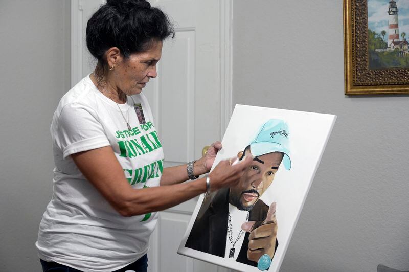 FILE - Mona Hardin recounts the events surrounding the death of her son, Ronald Greene, as she holds a painting of him in Orlando, Fla., on Saturday, Dec. 4, 2021. Hardin has been waiting five long years for any resolution to the federal investigation into her son’s deadly arrest by Louisiana State Police troopers, an anguish only compounded by the fact that nearly every other major civil rights case during that time has passed her by. (AP Photo/Phelan M. Ebenhack, File)