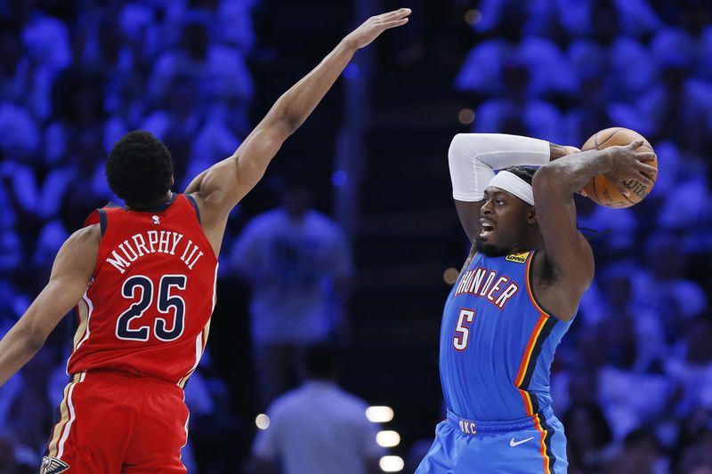 Oklahoma City Thunder guard Luguentz Dort (5) looks to pass the ball away from New Orleans Pelicans guard Trey Murphy III (25) during the second half in Game 2 of an NBA basketball first-round playoff series Wednesday, April 24, 2024, in Oklahoma City. (AP Photo/Nate Billings)