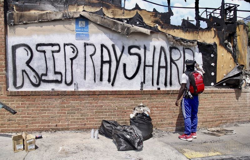 Joseth Jett spray-painted over graffiti from the night before, then painted “RIP Rayshard” on June 14, 2020, at the south Atlanta Wendy’s where Rayshard Brooks was shot and killed by Atlanta police on June 12 during a struggle in a Wendy’s parking lot. (Steve Schaefer for The Atlanta Journal Constitution)