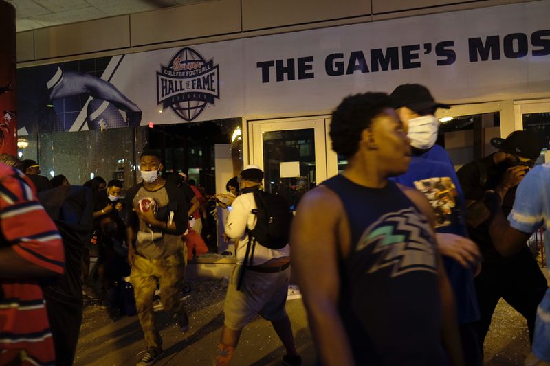 Protesters outside the College Football Hall of Fame Friday night. The HOF was defaced as crowds broke windows and went inside and took items.