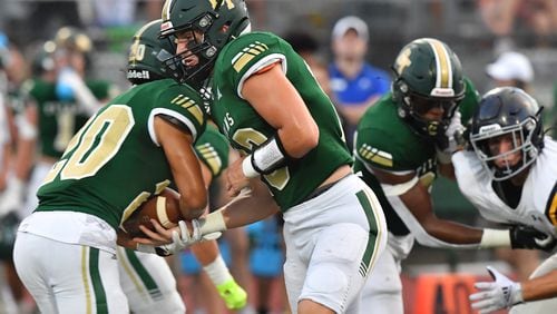 August 27, 2021 Roswell - Blessed Trinity's QB JC French (13) makes a handoff to Blessed Trinity's Evan Dickens (20) in the first half at Blessed Trinity Catholic High School in Roswell on Friday, August 27, 2021. (Hyosub Shin / Hyosub.Shin@ajc.com)