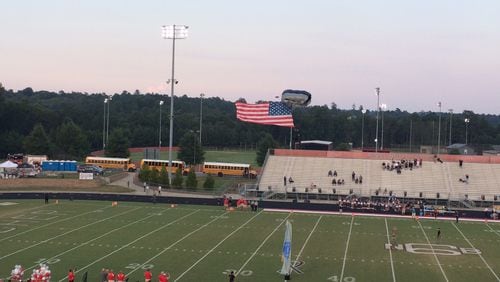 Military paratroopers delivered the flag in a pregame ceremony at Archer.