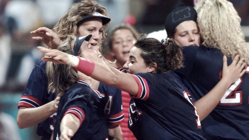 Dot Richardson (left) hugs Lisa Fernandez as Michele Smith (behind Dot) gets ready to celebrate the Americans' win of the first gold medal in the sport of softball on July 30, 1996, during the 1996 Summer Olympics in Columbus. (Renee Hannans/AJC)