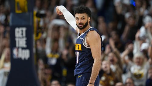 Denver Nuggets guard Jamal Murray looks back at the Los Angeles Lakers bench after hitting a 3-point basket late in the second half of Game 5 of an NBA basketball first-round playoff series Monday, April 29, 2024, in Denver. (AP Photo/David Zalubowski)