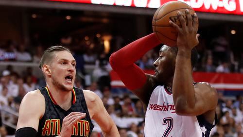 Washington Wizards guard John Wall, right, looks for a receiver while Atlanta Hawks forward Mike Muscala, left, defends during the first half in Game 1 of a first-round NBA basketball playoff series, in Washington, Sunday, April 16, 2017. (AP Photo/Manuel Balce Ceneta)