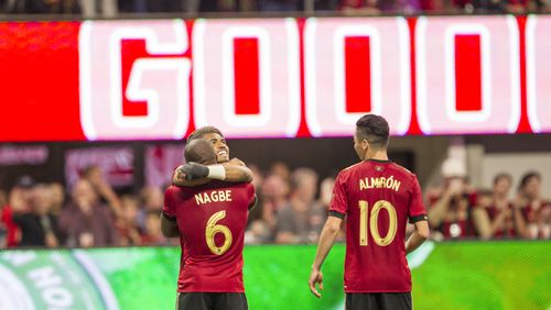 Atlanta United forward Josef Martinez (7) hugs Atlanta United midfielder Darlington Nagbe (6) after Nagbe makes a goal during the match between NYC FC and Atlanta United at Mercedes-Benz Stadium in Atlanta, Georgia, on Sunday, April 15, 2018. The goal was later taken away due to a penalty. (REANN HUBER/REANN.HUBER@AJC.COM)