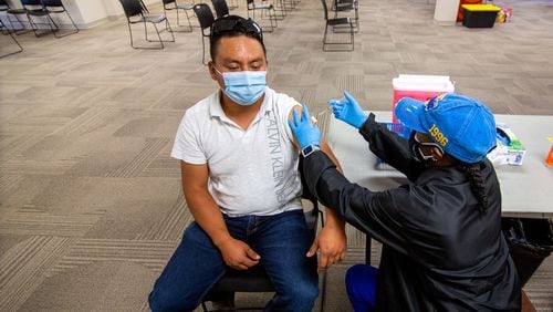 Nurse Lydia Shakespeare-Edwards gives Oscar Chavero his COVID-19 vaccination at the Mexican Consulate in Atlanta on July 16, 2021. (Steve Schaefer for The Atlanta Journal-Constitution)