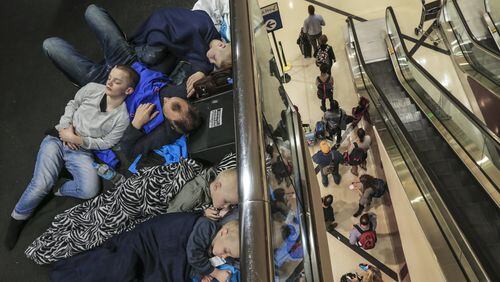 Members of the Ravnevand family, from Norway, were among thousands encamped at Hartsfield-Jackson after Wednesday evening’s storms. Many travelers were still trying to get rebooked on flights Thursday. JOHN SPINK /JSPINK@AJC.COM