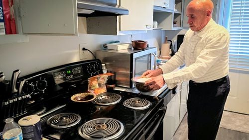 Santiago Murat cooks a meal at his Atlanta apartment on Tuesday, February 27, 2023. Murat, who had lived on The Hill, one of the biggest homeless encampments in Atlanta, now has an apartment of his own through a program with the city. Matt Kempner / The Atlanta Journal-Constitution