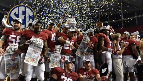 Alabama in its usual December pose - celebrating another SEC Championship Game victory, this over Florida last year. (AJC photo)