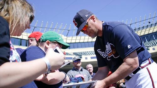 Former Atlanta Braves third baseman and special assistant to baseball operations, Chipper Jones, right, signs autographs for fans before a spring training baseball game against the Boston Red Sox, Friday, March 3, 2017, in Kissimmee, Fla. (AP Photo/John Raoux)