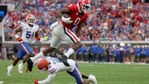 Georgia Bulldogs tight end Darnell Washington (0) leaps against Florida Gators safety Trey Dean III (0) after a reception during the first quarter in a NCAA football game at TIAA Bank Field, Saturday, October 29, 2022, in Jacksonville, Florida. (Jason Getz / Jason.Getz@ajc.com)