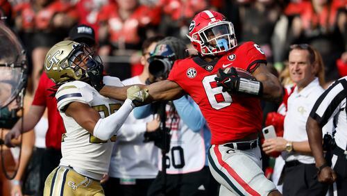Bulldogs running back Kenny McIntosh fights off Yellow Jackets defensive back LaMiles Brooks during the fourth quarter Saturday in Athens. McIntosh gained 83 yards on the play. Georgia won 37-14. (Jason Getz / Jason.Getz@ajc.com)