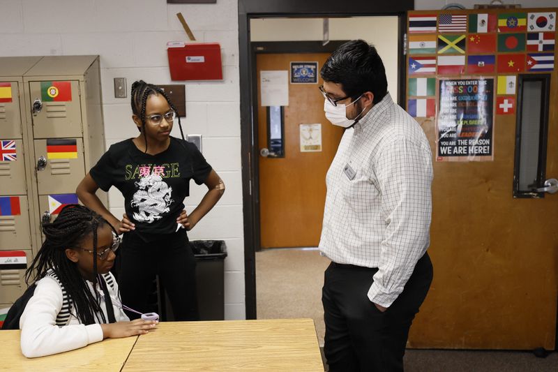 Daniel Garcia, a social studies teacher at Shiloh Middle School in Gwinnett County, chats with a student as she and a classmate wait for dismissal. Despite facing several challenges during the academic year, Garcia remains steadfast in inspiring and motivating his students to reach their full potential. Miguel Martinez /miguel.martinezjimenez@ajc.com