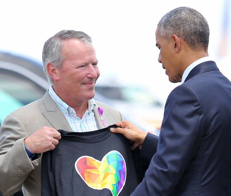 President Barack Obama looks at a T-shirt that was presented to him by Orlando, Fla. Mayor Buddy Dyer upon the president's his arrival at Orlando International Airport, Thursday, June 16, 2016, in Orlando, Fla. Obama is in Orlando today to pay respects to the victims of the Pulse nightclub shooting and meet with families of victims of the attack. (Joe Burbank/Orlando Sentinel via AP)