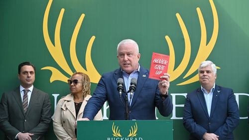 Bill White, chairman and CEO of the Buckhead City Committee, holds a book titled "Never Give Up" as he begins speaking to members of the press during a news conference to discuss an important series of next steps outside the Buckhead City Committee headquarters on Tuesday, February 18, 2022. (Hyosub Shin / Hyosub.Shin@ajc.com)