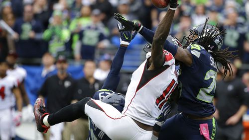 Seattle Seahawks cornerback Richard Sherman, right, and Earl Thomasbreak up a pass intended for Falcons receiver Julio Jones on Sunday, Oct. 16, 2016, in Seattle. The Seahawks beat the Falcons 26-24 but the teams meet again Saturday in the playoffs. (AP Photo/Elaine Thompson)
