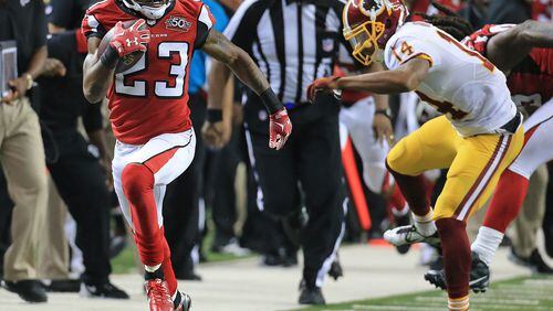 Falcons cornerback Robert Alford intercepts Redskins quarterback Kirk Cousins and breaks away from wide receiver Ryan Grant during sudden death and returns it for the game winning touchdown and a final score of 25-19 in their football game on Sunday, Oct. 11, 2015, in Atlanta. The Falcons remain perfect at 5-0 with the victory.    Curtis Compton / ccompton@ajc.com