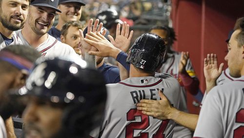 Atlanta Braves' Austin Riley is congratulated in the dugout after scoring against the Arizona Diamondbacks during the fifth inning of a baseball game Saturday, June 3, 2023, in Phoenix. (AP Photo/Darryl Webb)