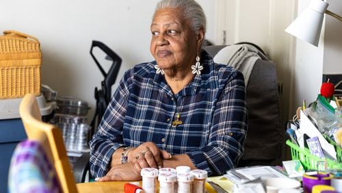 Irene McGibbon, 75, poses for a portrait at her home with her medicine on display in Atlanta on Tuesday, April 25, 2023. (Arvin Temkar / arvin.temkar@ajc.com)