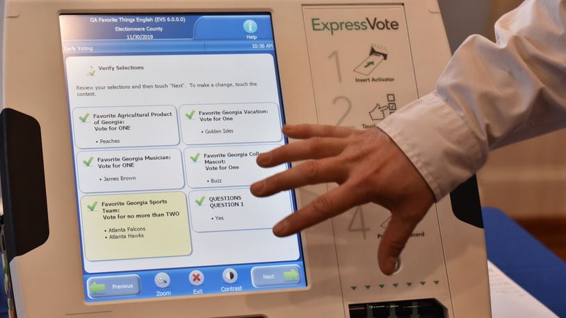 Tobey Dingbaum with Election Systems & Software demonstrates his company's ballot-marking device voting system in this January file photo. HYOSUB SHIN / HSHIN@AJC.COM