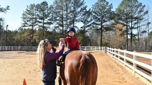 Jessica Moore works with 3-year-old Greyson O’Conor. Moore is the founder of a nonprofit that uses equine therapy to help children with special needs. CONTRIBUTED